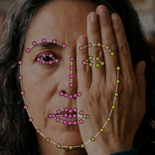 Hand over left eye: the hidden eye, brow and jaw side coloured olive, visible landmarks pink.